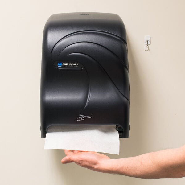 A black San Jamar Smart System paper towel dispenser on a wall.