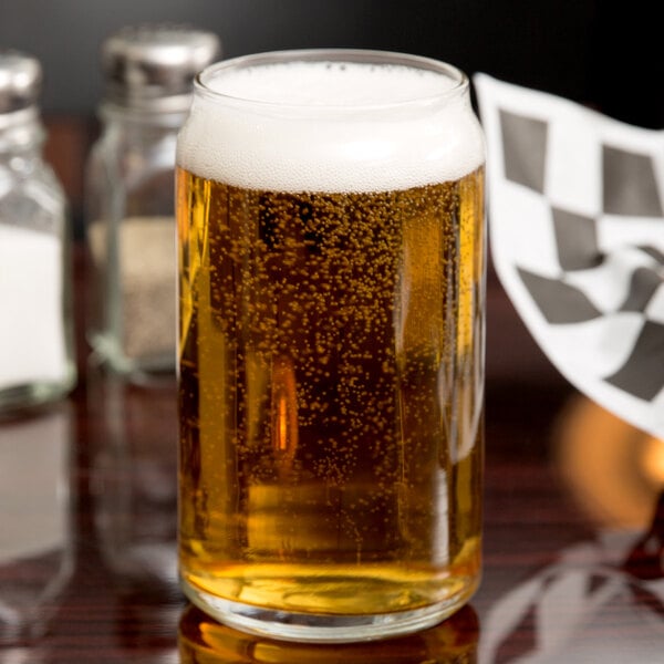 A Libbey beer glass filled with beer on a table.