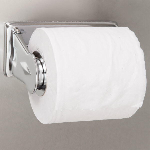 A San Jamar chrome metal toilet paper holder with a roll of toilet paper.
