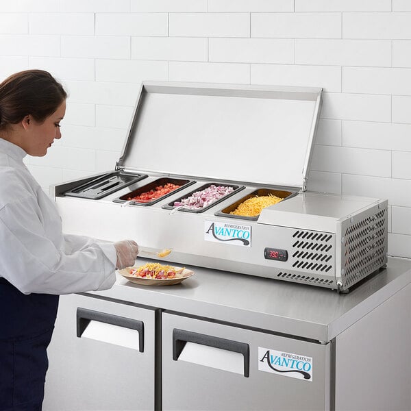 An Avantco Countertop Refrigerated Prep Rail on a commercial kitchen counter with food in containers.