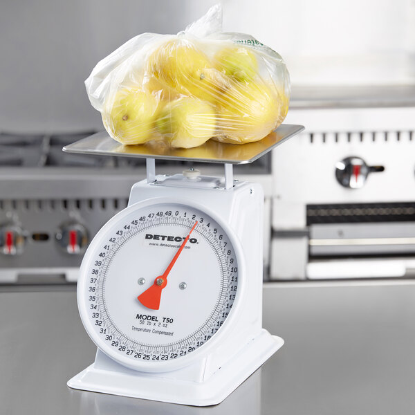 A Cardinal Detecto T50 mechanical portion scale with a bag of lemons on it.
