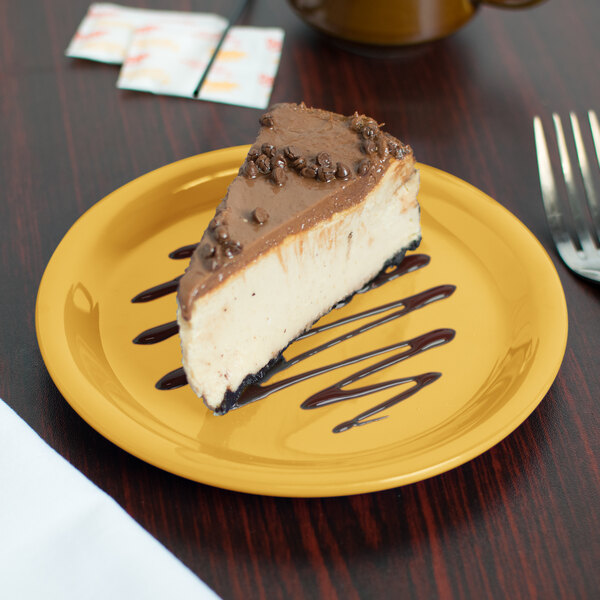 A piece of cheesecake on a Carlisle honey yellow melamine plate.