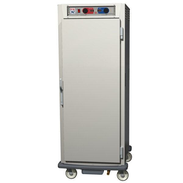 A stainless steel Metro C5 heated holding and proofing cabinet with solid doors on wheels.