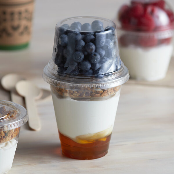 A 12 oz. Parfait Cup with Fabri-Kal Insert and lids filled with yogurt, blueberries, and granola.