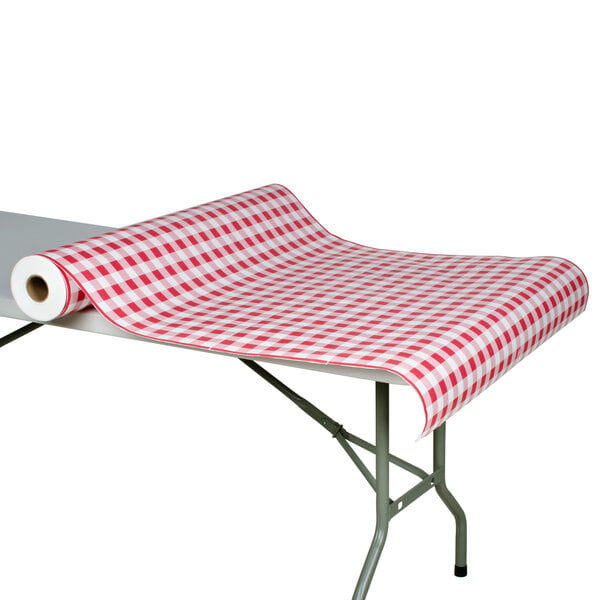 A table with a red and white checkered Paper Table Cover with Red Gingham Pattern on it.