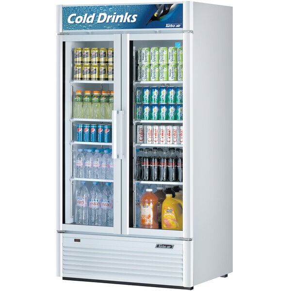 A Turbo Air white glass door refrigerator full of drinks and bottles.
