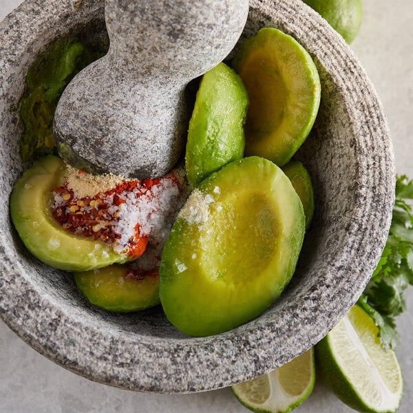 Wholly Guacamole IQF Hass Avocado Halves in a bowl with lime and salt.