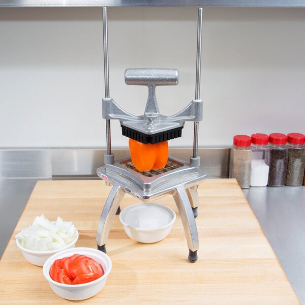 A Nemco Easy Chopper II dicing onions on a cutting board in a professional kitchen.