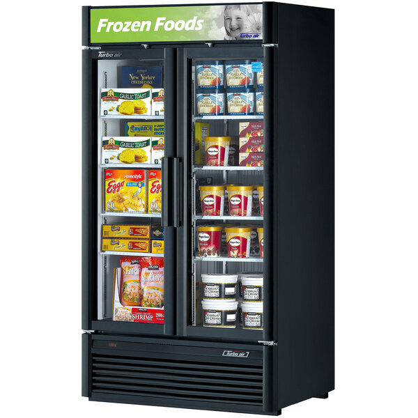 A black Turbo Air glass door merchandising freezer with food inside.