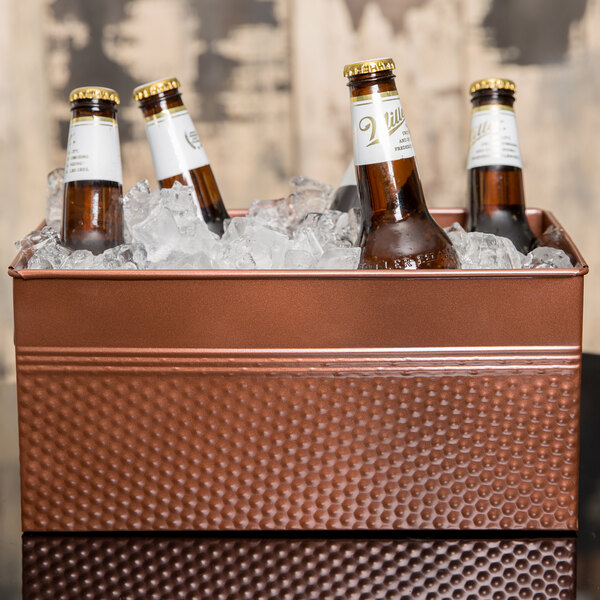 An American Metalcraft copper rectangular beverage tub with ice holding six beer bottles.