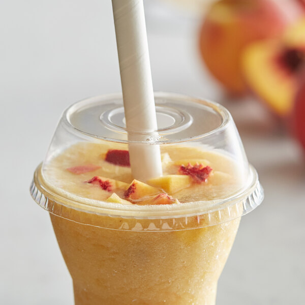 A smoothie with a Dome PET Lid and a straw in a drink with peach slices.