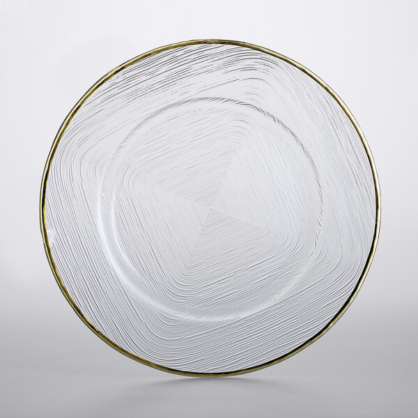 A clear glass plate with a gold weave rim.