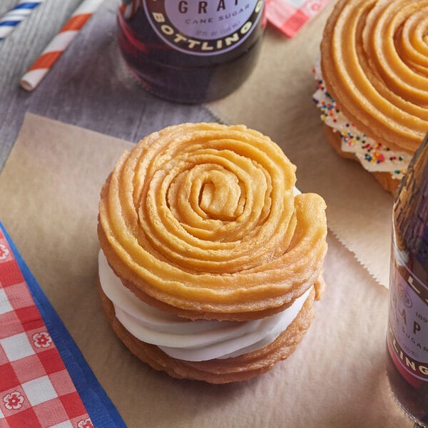 A J & J Snack Foods Hola Churro sandwich bun on a table with another pastry.