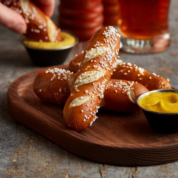 A plate of J & J Bavarian Bakery Mini Soft Pretzel Sticks with mustard for dipping.