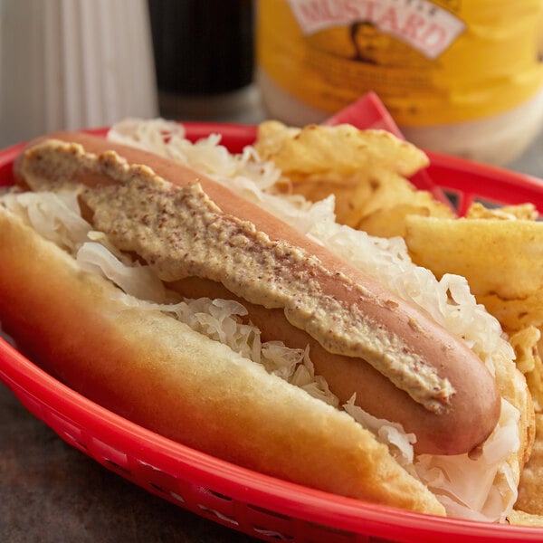 A Pilsudski mustard-topped hot dog with a side of fries on a restaurant table.