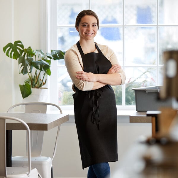 A woman in a black Choice apron stands at a farm-to-table restaurant counter.