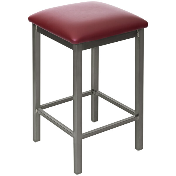A BFM Seating clear coated steel counter height bar stool with a burgundy vinyl seat.