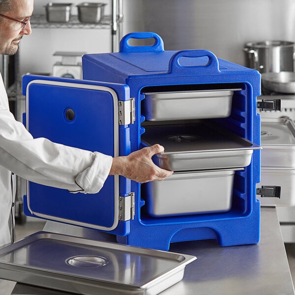 A man in a white coat opening a blue CaterGator food pan carrier.
