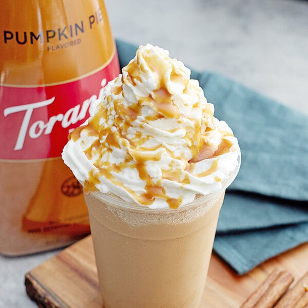 A cup of coffee with whipped cream and Torani Pumpkin Pie Sauce on top.