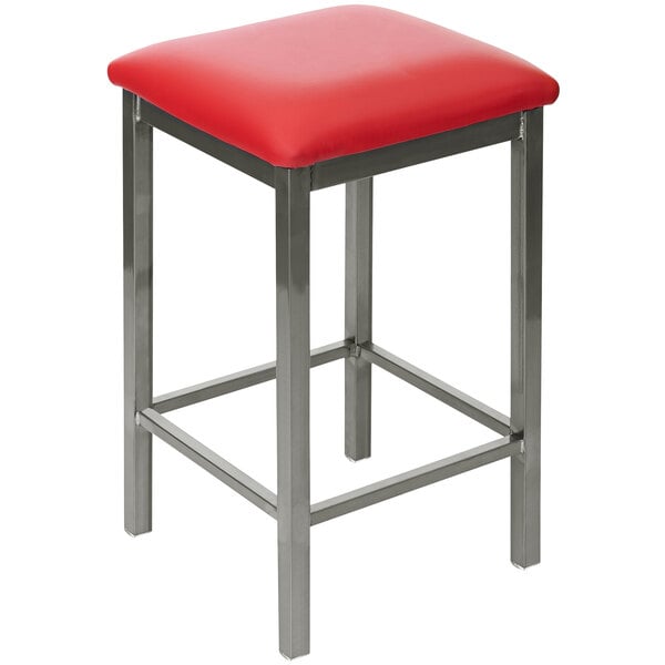 A BFM Seating red vinyl counter height bar stool with a metal frame.