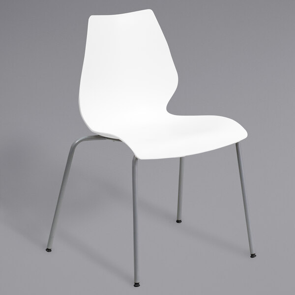 A white Flash Furniture stack chair with metal legs.