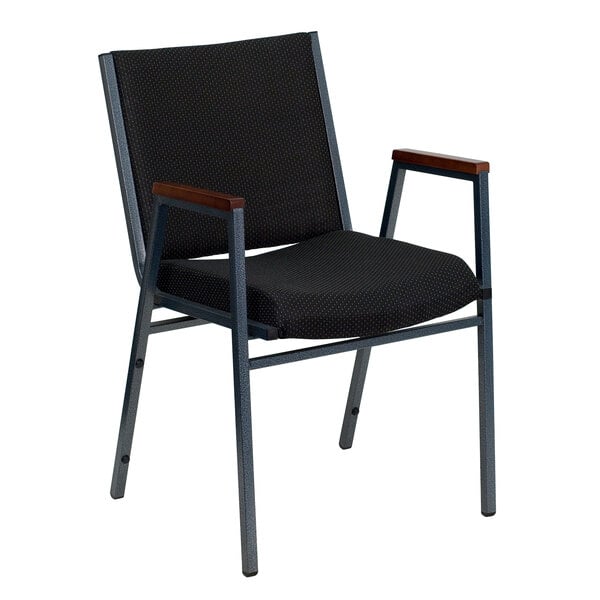 A black Flash Furniture stack chair with black dot fabric and wooden armrests.
