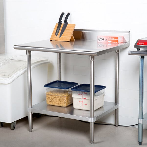 An Advance Tabco stainless steel work table with containers of food.