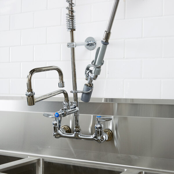 A T&S pre-rinse faucet with a hose above a kitchen sink.