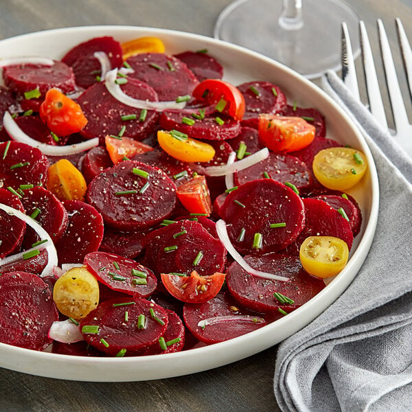 A plate of beets and tomatoes on a table.