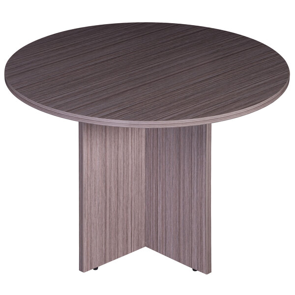 A Boss Driftwood laminate round office table with a pedestal base.