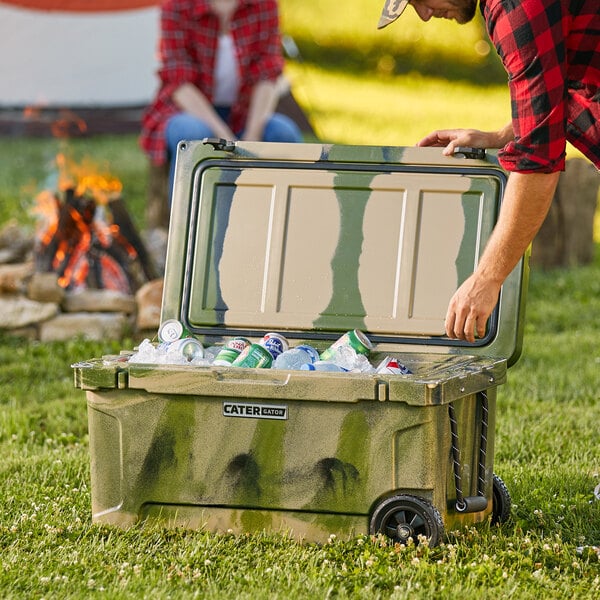 A man opening a CaterGator camouflage cooler filled with cans.
