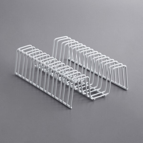 A row of white metal racks on a gray surface.