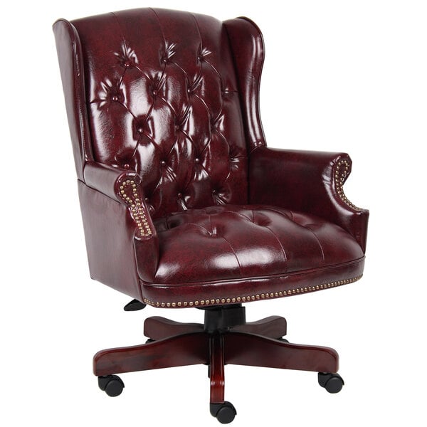 A red leather Boss office chair with buttoned back and gold studs.