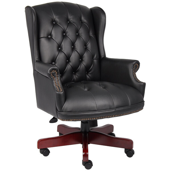 A black leather Boss office chair with a wooden base.