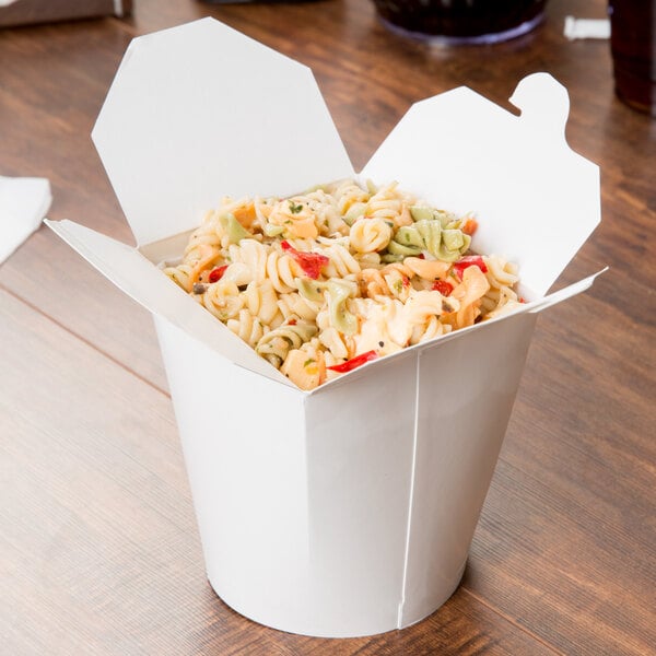 A white SmartServ paper take-out container filled with noodles and vegetables.