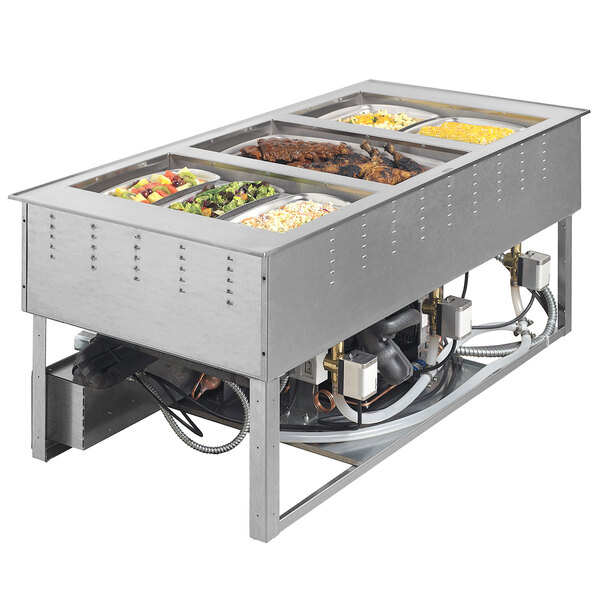 A Vollrath drop-in hot food well with trays of food.