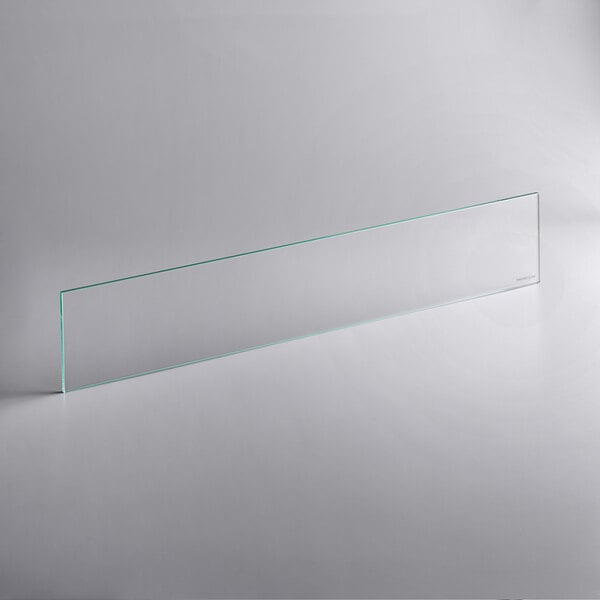 A clear rectangular glass shelf with green lines on a white surface.