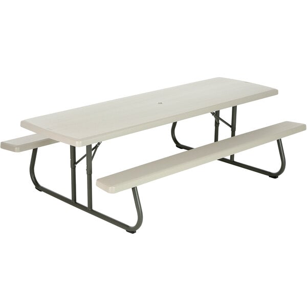 A white picnic table with attached benches.