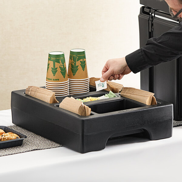 A black Cambro condiment holder on a table in a hotel buffet.