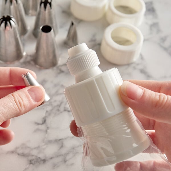 A hand using an Ateco plastic coupler on a white plastic bottle.