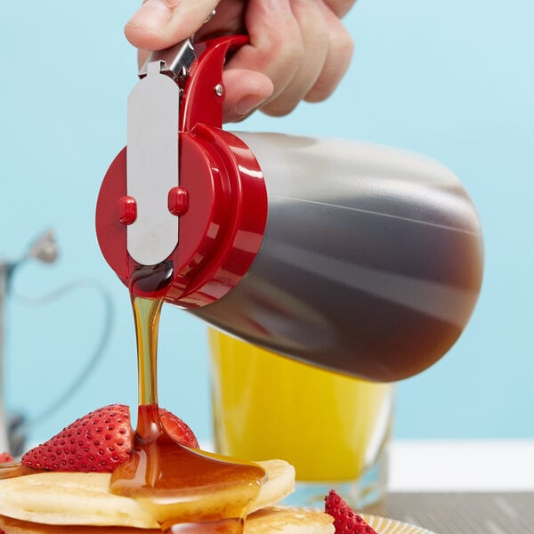 A person pouring Tablecraft syrup on a plate of pancakes.