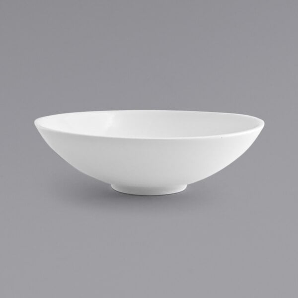 A close up of a Front of the House white porcelain wide bowl with a spiral design.