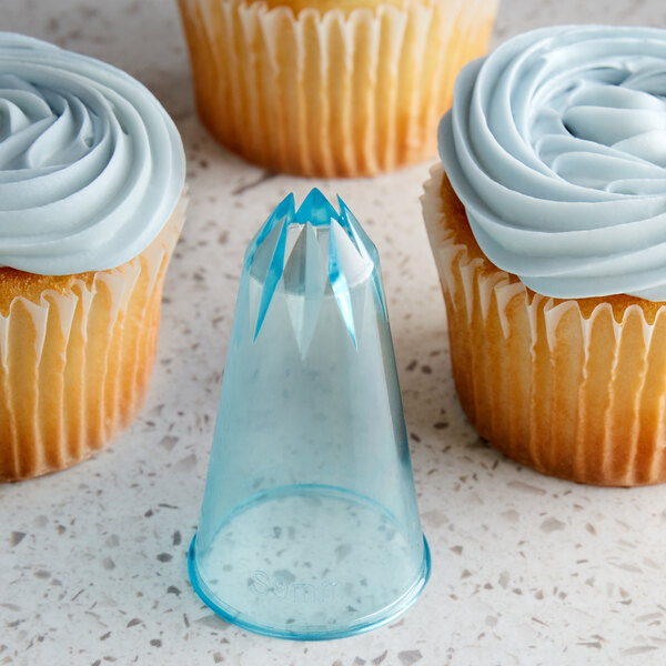 A cupcake with blue frosting piped with an Ateco closed star piping tip.