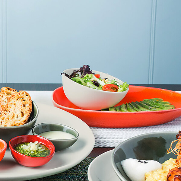 A table with plates of food and bowls of vanilla bean porcelain bowls on a table with food.