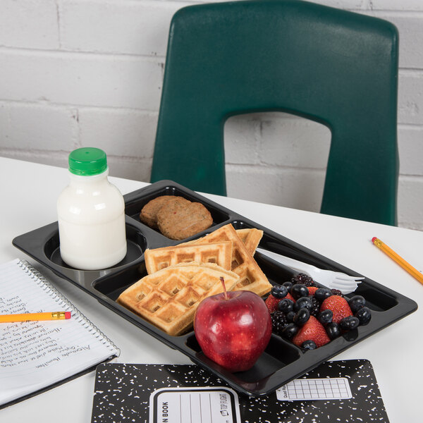 A Carlisle black 6 compartment tray with waffles and fruit on it, including a bowl of fruit and a bottle of milk.