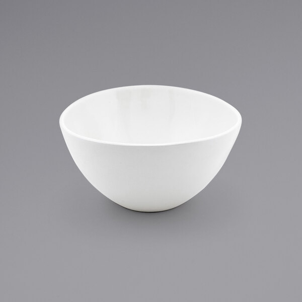A case of 12 white Front of the House Kiln porcelain bowls on a gray surface.