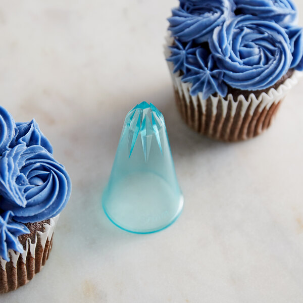 A blue cupcake with a piped frosting star using an Ateco closed star piping tip.