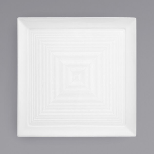A white square porcelain plate with a spiral pattern.