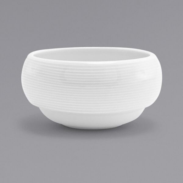 A white bowl with a white spiral design on a gray background.