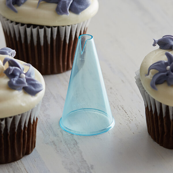 Cupcakes with purple frosting and a cone on top in a clear plastic cone.